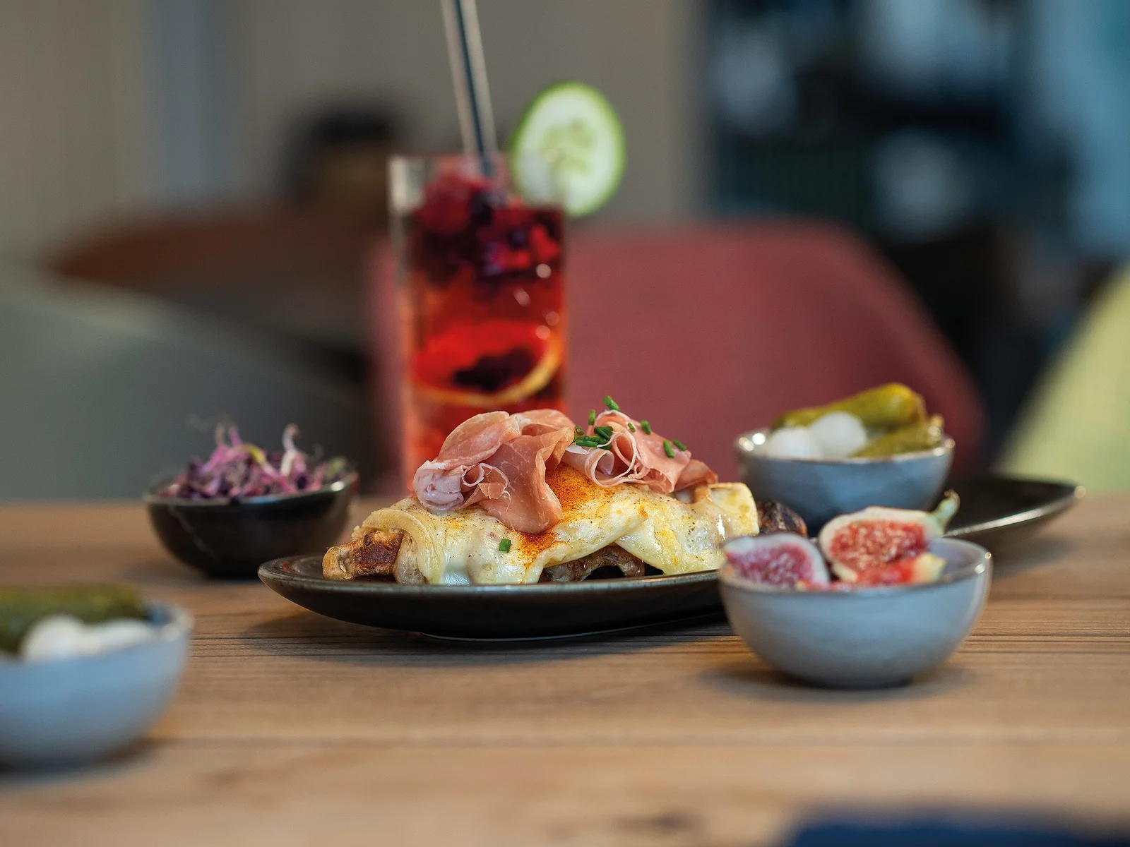 Croffle mit geschmolzenem Gletscherraclette, Rohschinken und Cornichons